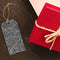 Gift tag with black bats next to a red box tied with twine