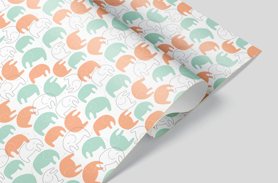 A sheet of wrapping paper with turquoise, orange and outlined elephants 