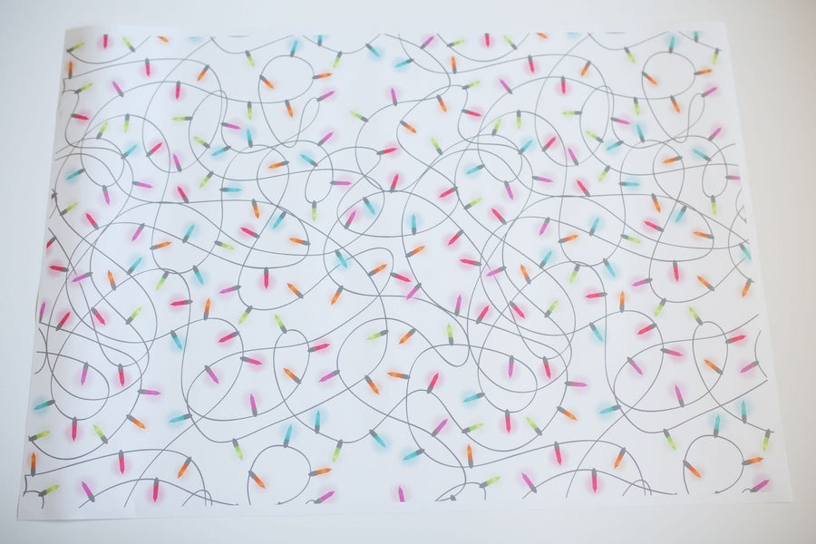 A White sheet of wrapping paper with Colorful Christmas Lights Tangled up